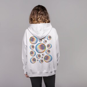 May include: White hooded sweatshirt with a colorful eye design on the back.