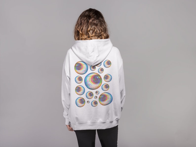 May include: White hooded sweatshirt with a colorful eye design on the back.