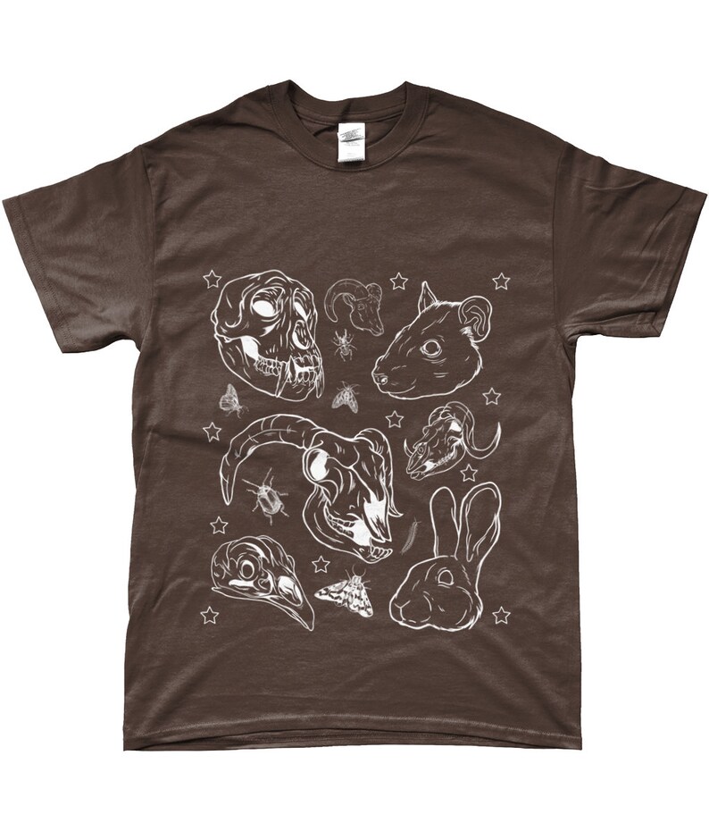 May include: A brown t-shirt with a white design of various animal skulls, insects, and stars. The design includes a monkey skull, a ram skull, a rat skull, a rabbit skull, a bird skull, and a rabbit.