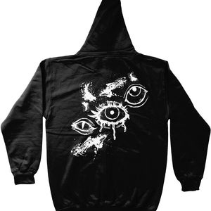 May include: Black zippered hoodie with a white graphic of three stylized eyes with dripping paint.