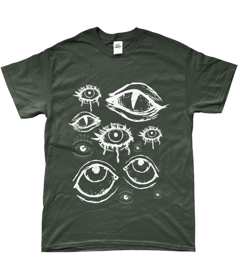 May include: Dark green t-shirt featuring a white graphic of multiple stylized eyes. The eyes vary in size and design, some with teardrop details. The shirt is a solid color, with a crew neck and short sleeves.