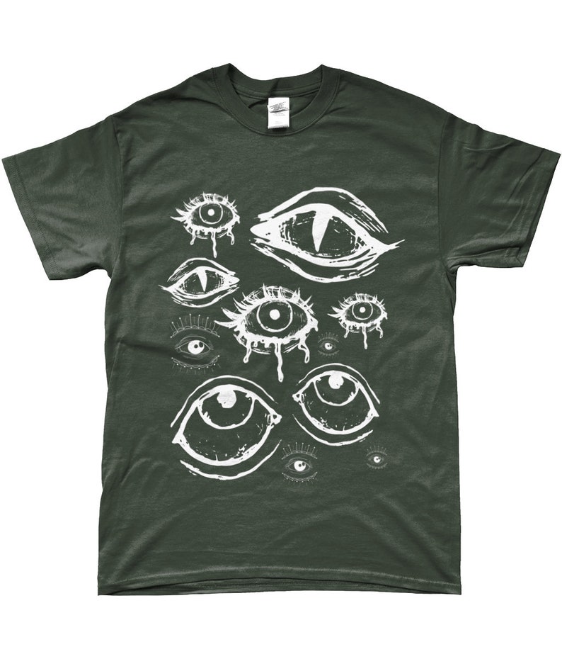 May include: A dark green t-shirt with a white graphic print of multiple stylized eyes. The eyes are drawn in a variety of shapes and sizes, some with dripping tears.