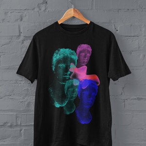 May include: Black t-shirt with a graphic print of colorful, abstract faces. The faces are layered and appear to be melting together.