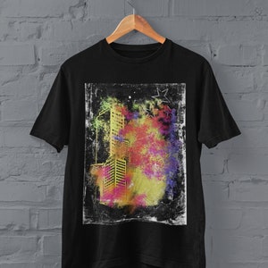 K&ouml;nnte beinhalten: Schwarzes T-Shirt mit einem grafischen Druck eines Stadtbildes in Gelb, Rosa und Blau mit einem Grunge-Effekt. Die Grafik ist von einem wei&szlig;en Rand umgeben.