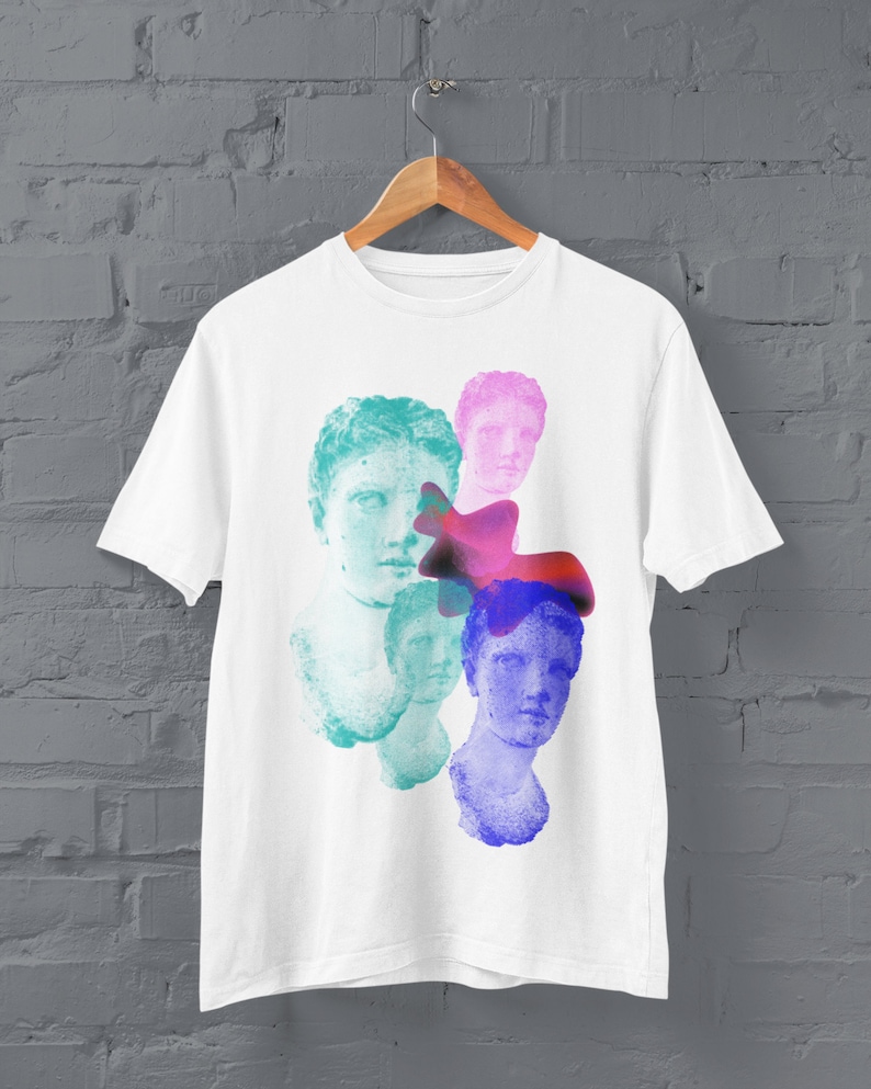 May include: White t-shirt with a colorful graphic print of four faces. The faces are partially obscured by abstract shapes in shades of pink, blue, and purple.
