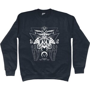 May include: A navy blue sweatshirt with a white graphic of a moth with antlers, mushrooms, and a crescent moon. The moth is surrounded by a geometric triangle design.
