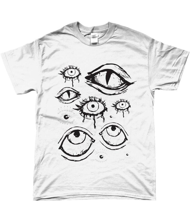 May include: White t-shirt with a black and white graphic print of multiple stylized eyes. The eyes are drawn in a variety of shapes and sizes, some with dripping tears.