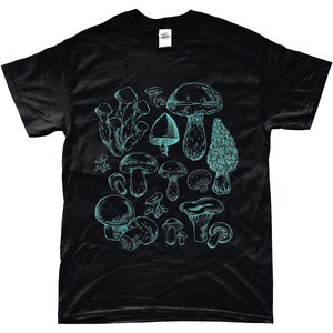 Op de afbeelding: Zwart T-shirt met een turquoise blauwe grafische afbeelding van verschillende paddenstoelen. De paddenstoelen zijn getekend in een vintage stijl.