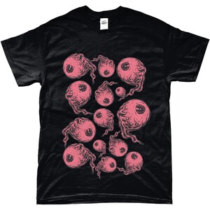 May include: Black t-shirt with a pink and white eye pattern. The eyes are drawn in a cartoon style and have a creepy, whimsical look.