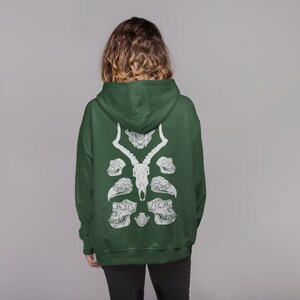 May include: A dark green hooded sweatshirt with a white graphic print of animal skulls on the back.