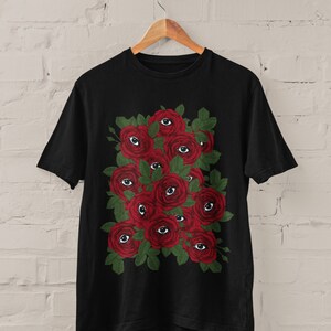 May include: Black t-shirt with a graphic print of red roses with eyes on them.