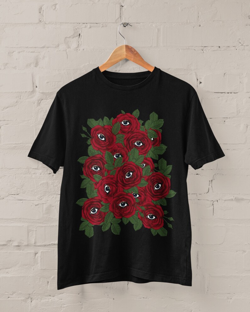 May include: Black t-shirt with a graphic print of red roses with eyes on them.