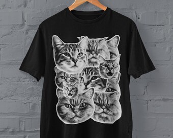 May include: Black t-shirt featuring a graphic print of several cat faces in black and white.