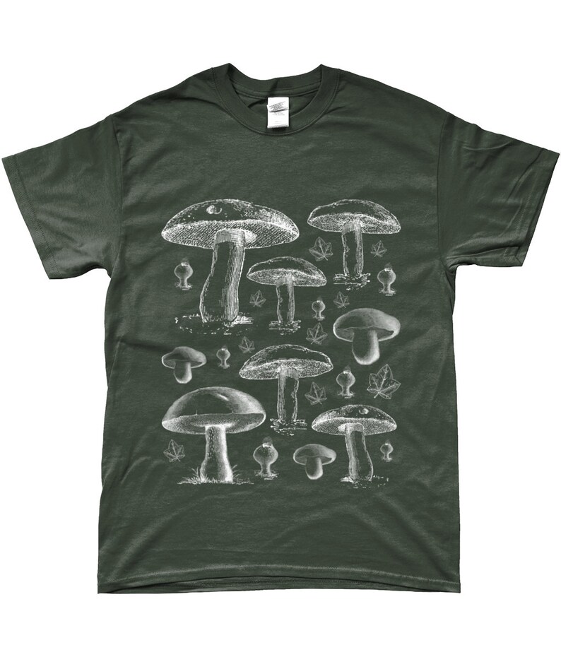 Puede incluir: Una camiseta verde oscuro con un estampado blanco de varios hongos. Los hongos est&aacute;n dibujados en un estilo vintage y est&aacute;n dispuestos en un patr&oacute;n aleatorio.