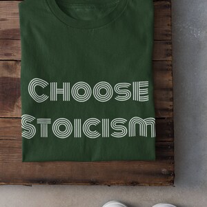May include: A dark green t-shirt with the text "CHOOSE STOICISM" in white outlined letters.