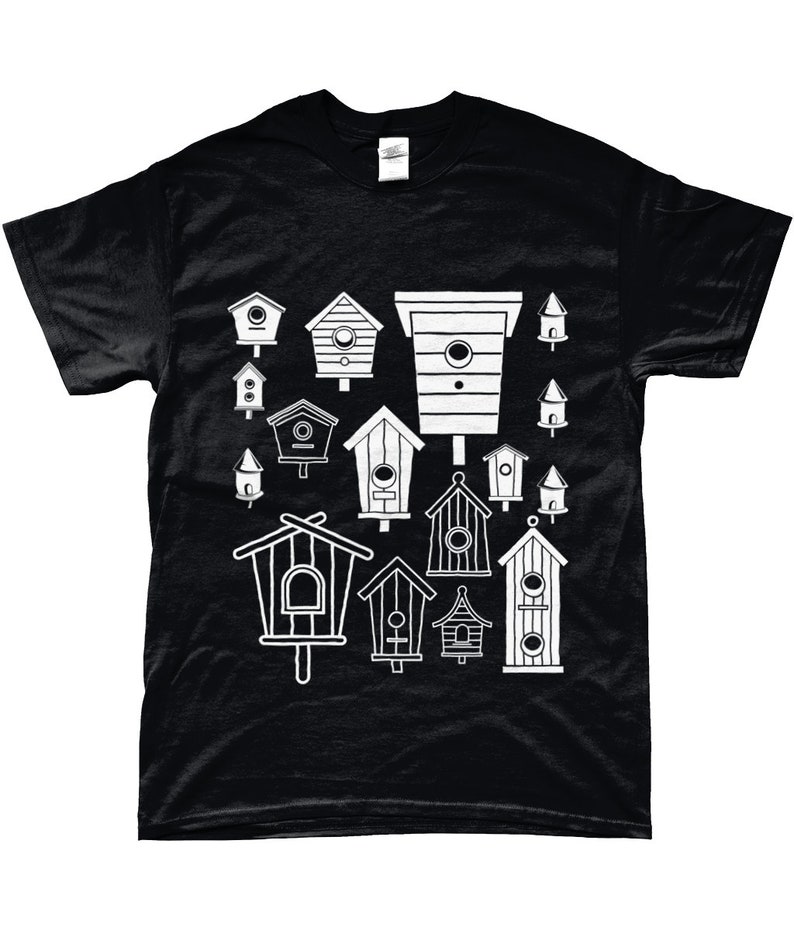 May include: Black t-shirt featuring a white design of various birdhouses in different shapes and sizes.