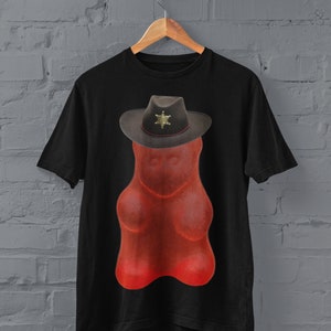 May include: A black t-shirt with a red gummy bear wearing a sheriff's hat. The hat has a gold star badge.