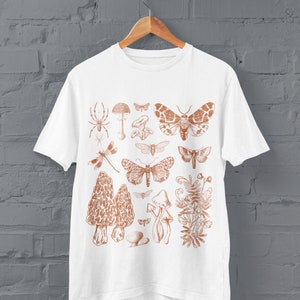 May include: White t-shirt featuring a brown print of various insects and mushrooms. The print includes butterflies, moths, a spider, a dragonfly, and mushrooms.