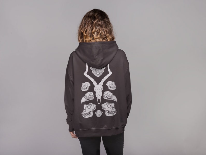 May include: A black hooded sweatshirt with a white graphic print of animal skulls on the back.