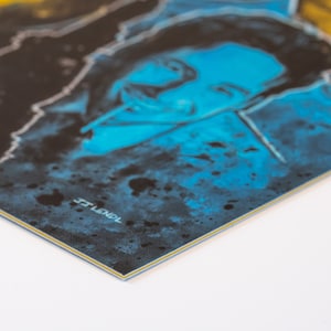 May include: Close-up of a blue and yellow abstract painting with a man's face in the center. The painting has a textured, splattered look. The text "TOWEL" is visible in the bottom right corner.