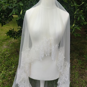 Two-tier cathedral wedding veil with blusher displayed on mannequin, light ivory color