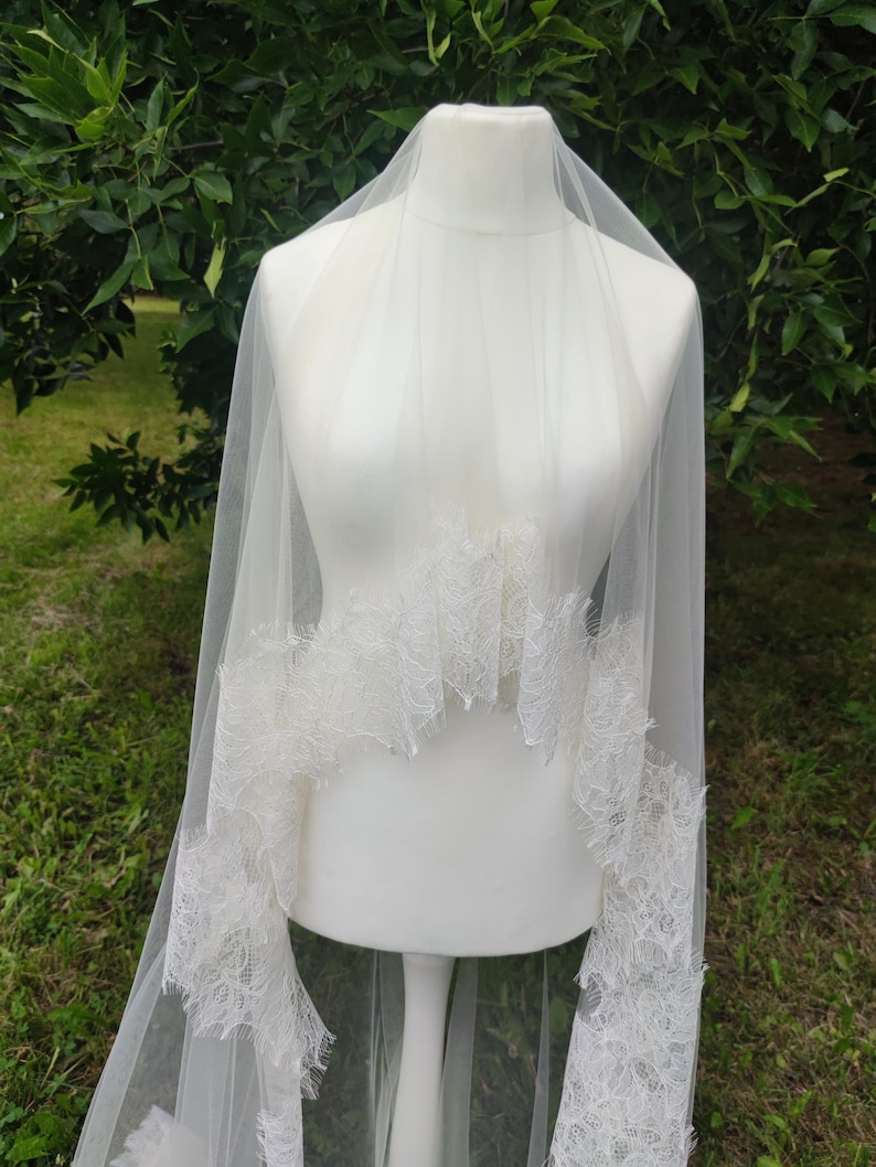 Two-tier cathedral wedding veil with blusher displayed on mannequin, light ivory color