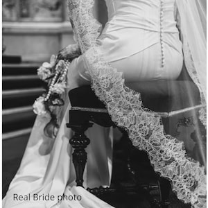 Black and white real bride photo wearing long cathedral lace wedding veil with blusher