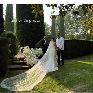 Real bride cathedral wedding veil with blusher in light ivory, long lace trim train outdoors