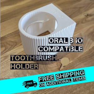 Könnte beinhalten: Ein weißer, 3D-gedruckter Zahnbürstenhalter mit dem Text "ORAL B IO COMPATIBLE TOOTHBRUSH HOLDER". Der Halter hat ein zylindrisches Design mit vertikalen Rippen und einer kreisförmigen Öffnung.