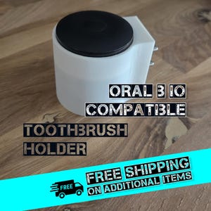Könnte beinhalten: Ein weißer Zahnbürstenhalter mit schwarzem Deckel, der mit Oral B IO kompatibel ist. Der Text "TOOTHBRUSH HOLDER" und "ORAL B IO COMPATIBLE" ist auf dem Halter aufgedruckt.