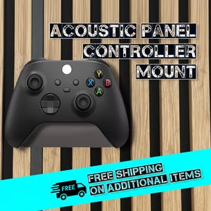 May include: Acoustic panel controller mount with a black game controller. The text "ACOUSTIC PANEL CONTROLLER MOUNT" is displayed above the controller. The background is a wooden panel with black stripes.