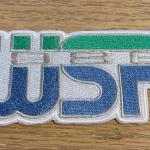 May include: White embroidered patch with the letters WSP in blue and silver, with a green and silver design above the letters.