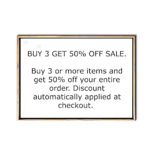 Op de afbeelding: Een ingelijst bord met de tekst "BUY 3 GET 50% OFF SALE." Koop 3 of meer artikelen en krijg 50% korting op je hele bestelling. De korting wordt automatisch toegepast bij het afrekenen.