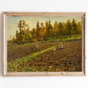 May include: A framed oil painting depicting a rural landscape with a group of people working in a field. The field is brown and the trees in the background are green. The sky is blue and there are clouds in the distance.