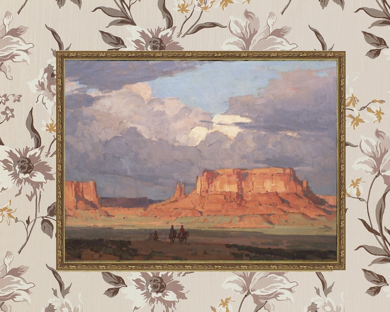 May include: A framed painting depicting a desert landscape with a large red rock formation in the background. The sky is cloudy and the sun is setting. There are three figures on horseback in the foreground.