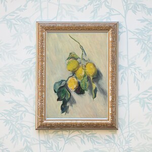 May include: A framed painting depicting a still life of lemons on a branch. The lemons are yellow and the branch has green leaves. The painting is set against a white background with a light blue floral pattern.
