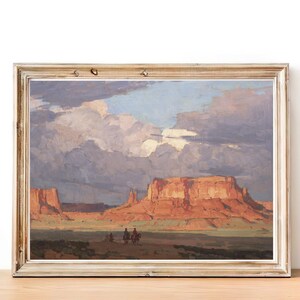 May include: A framed painting depicting a desert landscape with red rock formations and a cloudy sky. Three figures on horseback are visible in the distance.