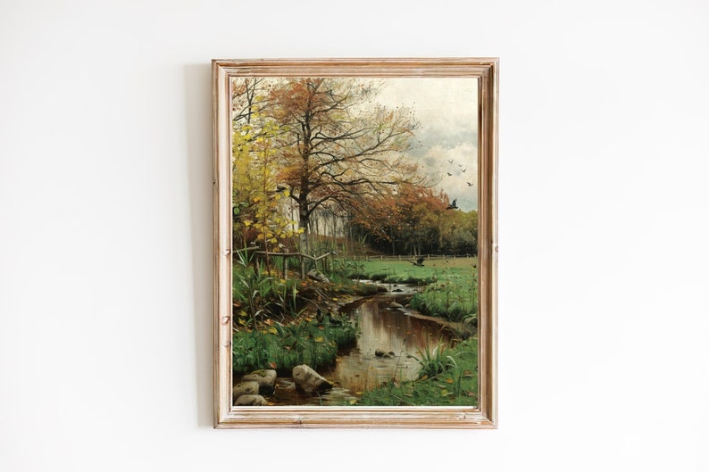 May include: A framed painting depicting a stream winding through a forest in autumn. The trees have yellow and orange leaves, and the sky is overcast. There are birds flying in the sky.