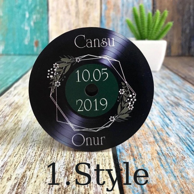 May include: Black vinyl record with a white geometric frame and floral design. The record has the text "Cansu" and "Onur" on it, along with the date "10.05.2019".