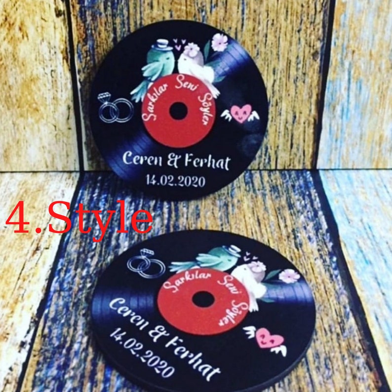 May include: Two black vinyl record coasters with red centers. The coasters feature a couple of birds with a heart and the text "Sarkilar Seni Soyler" in a circle. The text "Ceren & Ferhat 14.02.2020" is printed below the birds.