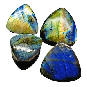 May include: Four polished labradorite gemstones. Each stone is triangular, displaying iridescent flashes of blue, green, and yellow. The stones have a smooth, glossy surface, and are set against a white background.