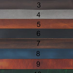 May include: A collection of eleven horizontal leather strips arranged in a stack, each labelled with a black number from 1 to 11. The strips display a variety of colours including shades of brown, grey, black, blue, red-brown, and dark green.