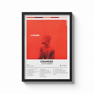 Puede incluir: Póster enmarcado con la portada del álbum "Changes" de Justin Bieber. La obra de arte es predominantemente roja con una foto de Bieber. El título del álbum y la lista de canciones se muestran en texto blanco. El póster está en un marco negro.