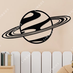 Op de afbeelding: Zwarte en witte silhouet van een planeet met ringen, een populair ontwerp voor wanddecoratie.