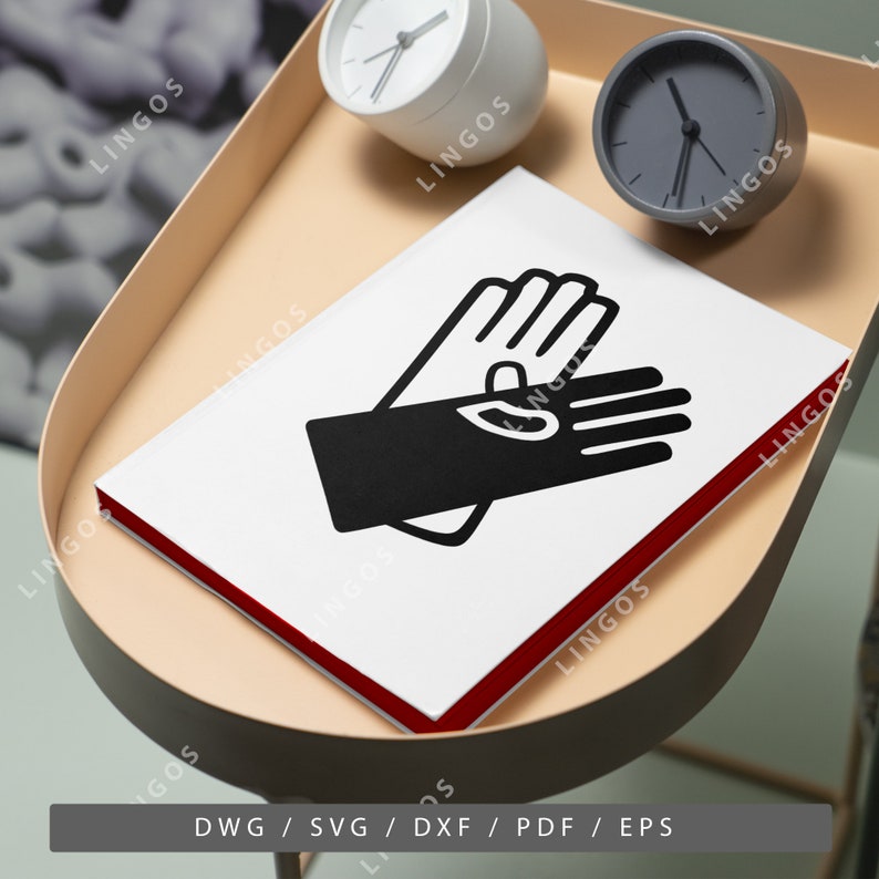 May include: A white notebook with a red border and a black illustration of two hands shaking. The notebook is on a light brown tray with two clocks.