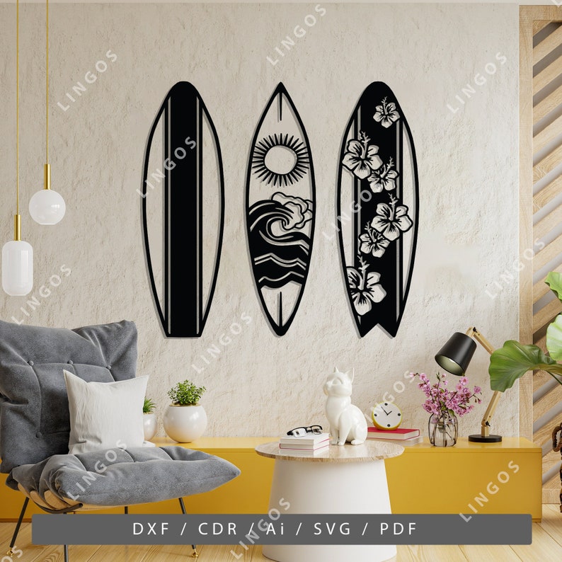 K&ouml;nnte beinhalten: Drei schwarze Metall-Surfbrett-Wanddekorationssilhouetten. Die Surfbretter sind in einer Reihe angeordnet, wobei das linke Surfbrett einen einzigen Streifen in der Mitte hat, das mittlere Surfbrett ein Sonnen-, Wellen- und Wasserdesign hat und das rechte Surfbrett ein florales Design hat.