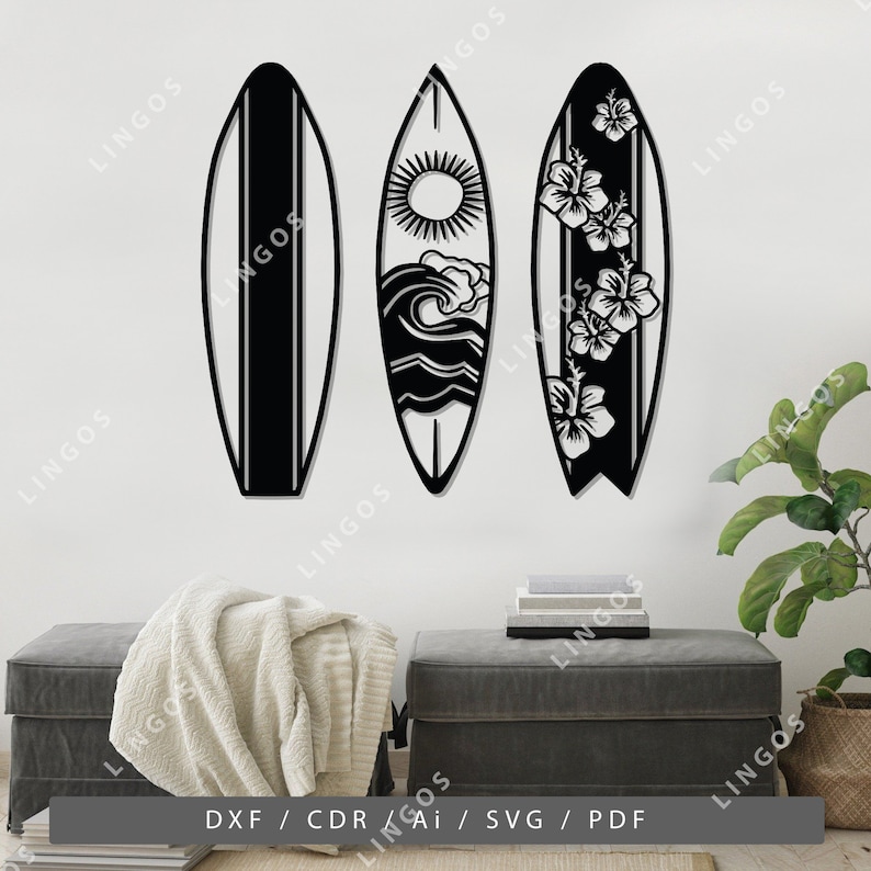 K&ouml;nnte beinhalten: Drei schwarze Wanddekorationen in Form von Surfbrettern mit verschiedenen Designs. Das linke Surfbrett ist schlicht, das mittlere Surfbrett hat eine Sonne, eine Welle und Wolken, und das rechte Surfbrett hat Hibiskusbl&uuml;ten.