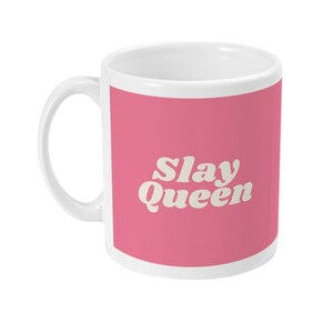 May include: White ceramic mug with a pink background and the text "Slay Queen" in a white retro font.