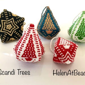 May include: A selection of beaded Christmas decorations in different shapes and colours. The ornaments include a black star, a teal teardrop, a green teardrop, a red and white tree, and a red and white cube. The text "Scandi Trees" and "HelenAtBeads" are visible.