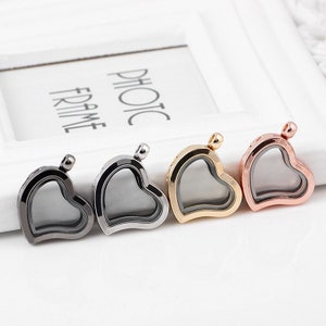 May include: Four heart-shaped locket pendants with clear glass inserts. The lockets are in silver, gold, rose gold, and black.